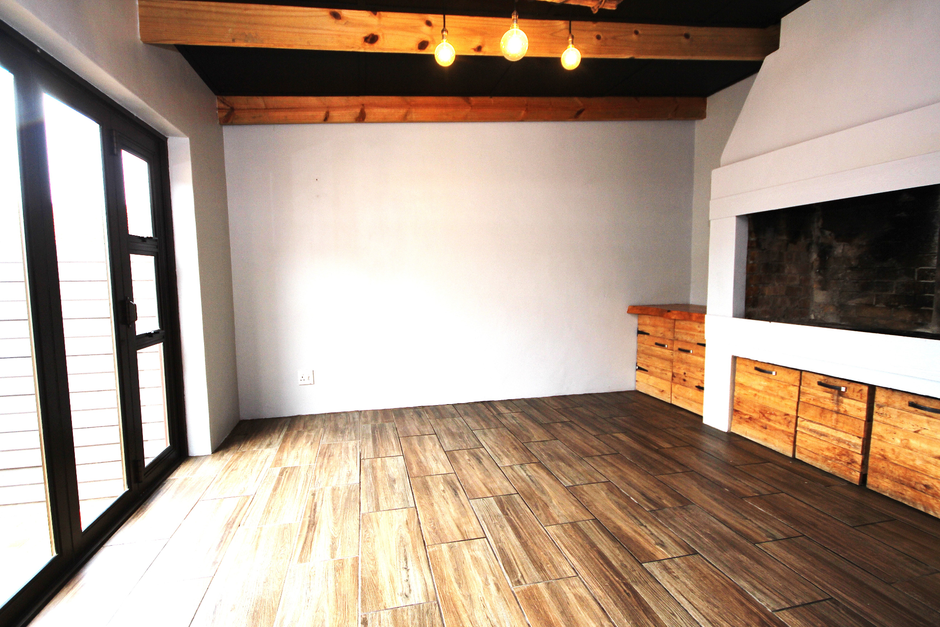 Braai room with wooden beams and pendant lights
